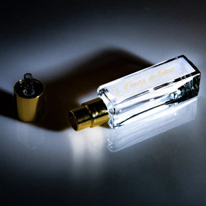 Cherigan - Fleurs de Tabac klarer Flakon mit goldenem Zerstäuber und abgenommener Kappe auf dunklem reflektierendem Untergrund
