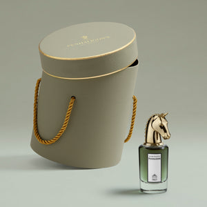 Penhaligon's - Portraits - Fortuitous Finley Flakon mit goldenem Pferdekopf vor eleganter grauer Geschenkbox mit goldener Kordel