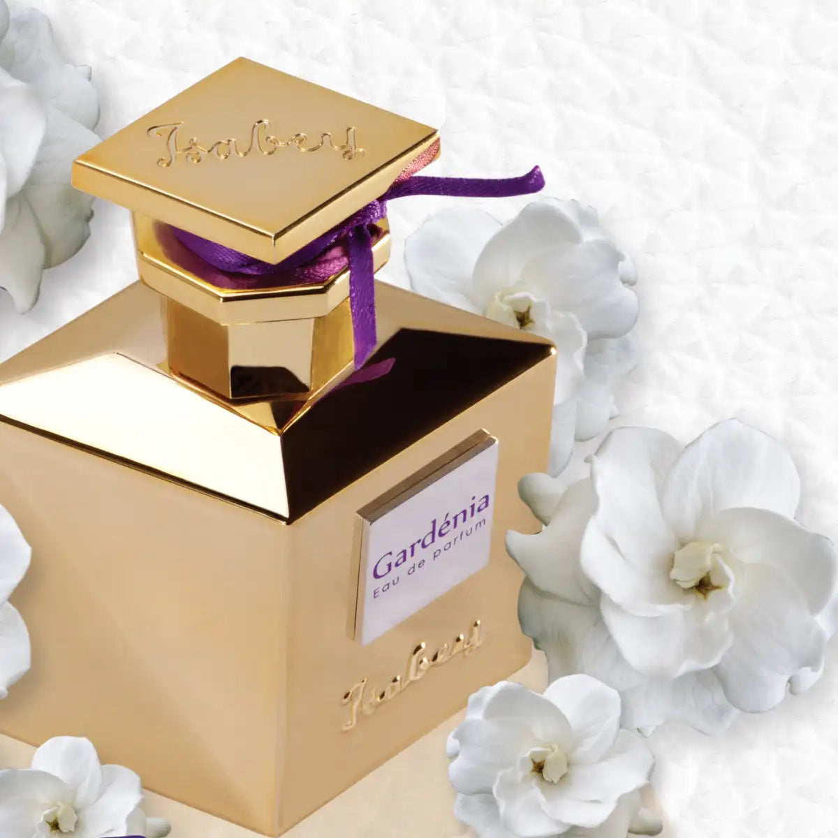 Isabey - Gardenia Parfumflakon in edlem goldfarbenem Design mit violetter Schleife und weißen Gardenienblüten auf weißem Hintergrund