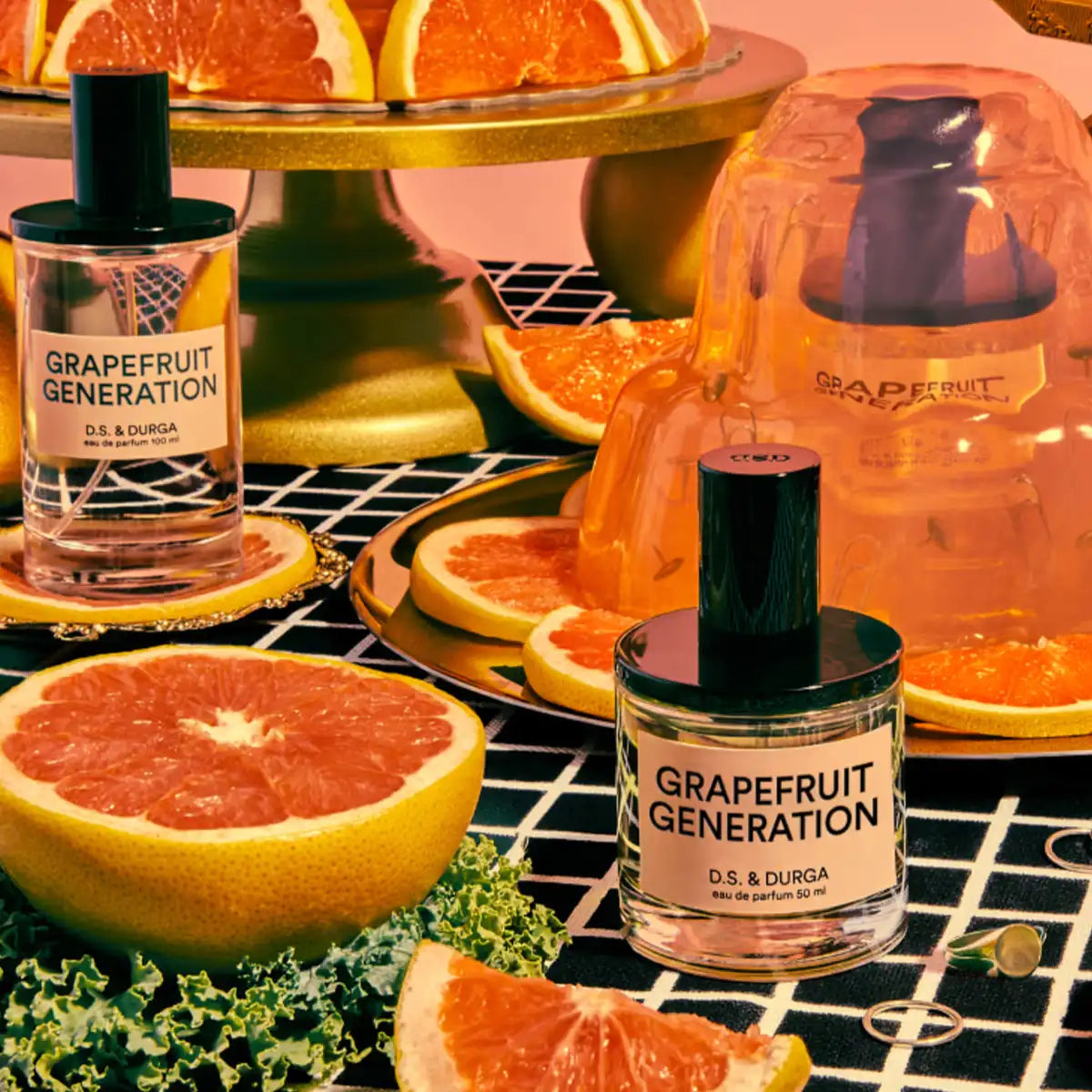 D.S. & Durga - Grapefruit Generation Parfumflakon vor frischen Grapefruits und goldfarbenem Deko-Untergrund