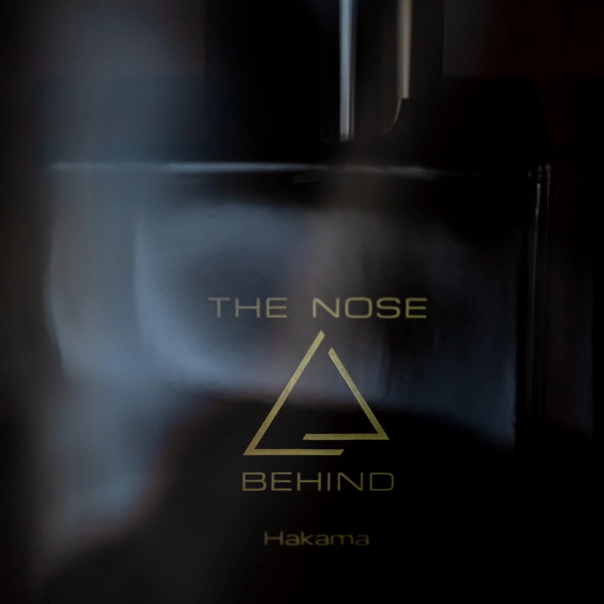 The Nose Behind - Hakama zeigt dunklen, eleganten Flakon mit minimalistischem goldfarbenem Schriftzug auf matter Oberfläche