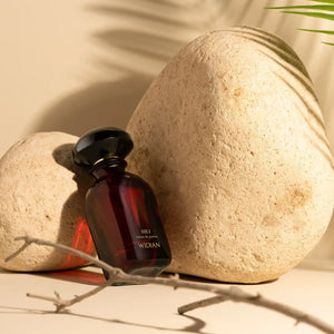 Widian - Velvet Collection - Hili Parfumflakon in tiefrotem Glas mit schwarz glänzendem Verschluss vor naturfarbenem Hintergrund