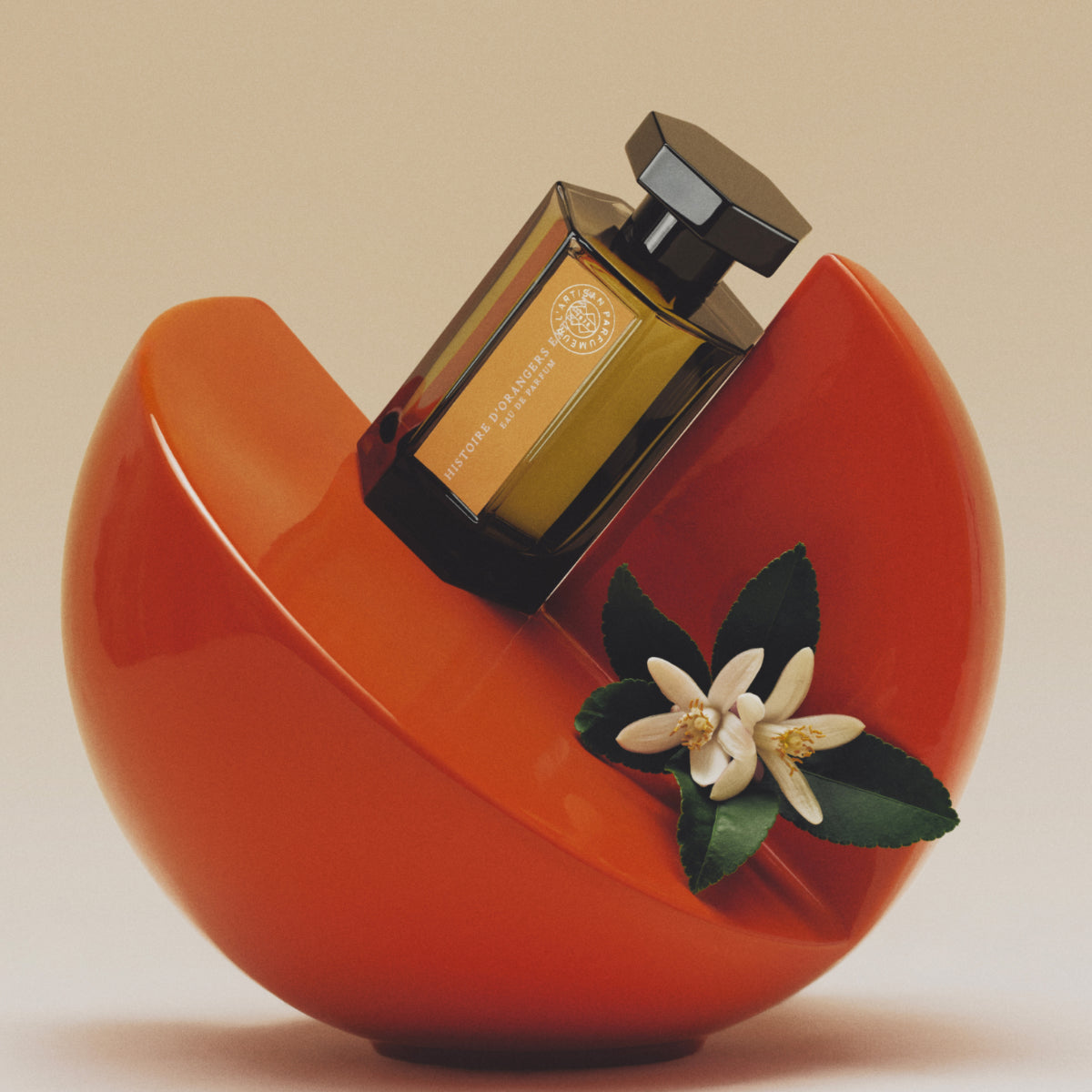 L'Artisan Parfumeur - La Collection - Histoire d'Orangers Extrême Parfumflakon auf orangefarbener, moderner Skulptur mit Orangenblüte