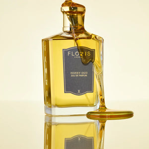 Floris - Honey Oud Parfümflakon mit honiggelber Flüssigkeit und goldfarbenem Verschluss in minimalistischem Stil