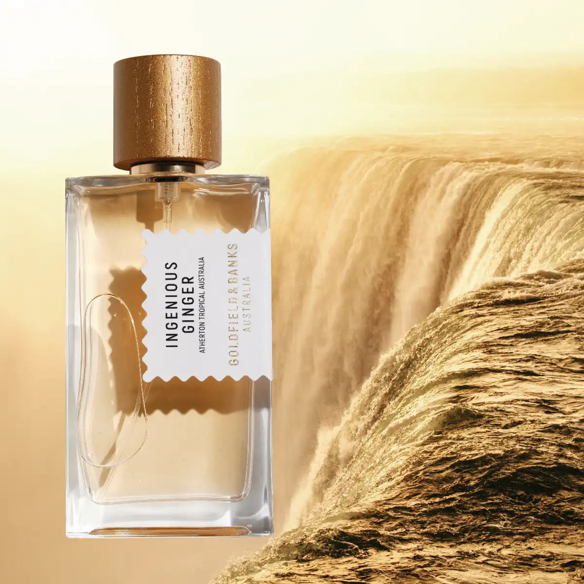 Goldfield & Banks - Native Collection - Ingenious Ginger zeigt klaren Flakon mit holzfarbenem Verschluss vor goldenem Wasserfallhintergrund