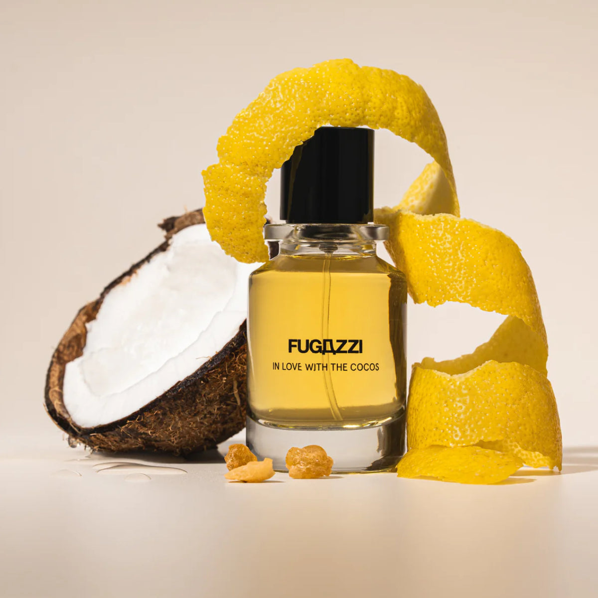 Fugazzi - In Love with the Cocos Parfumflakon mit gelbem Duft, Kokosnuss und Zitronenschale vor hellem Hintergrund