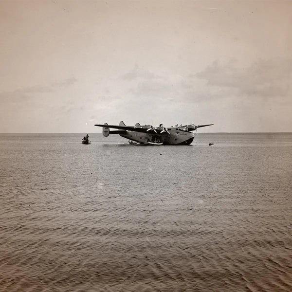 Cherigan - Iris Coffee historische Aufnahme eines Wasserflugzeugs auf offenem Meer mit ruhiger Wasseroberfläche