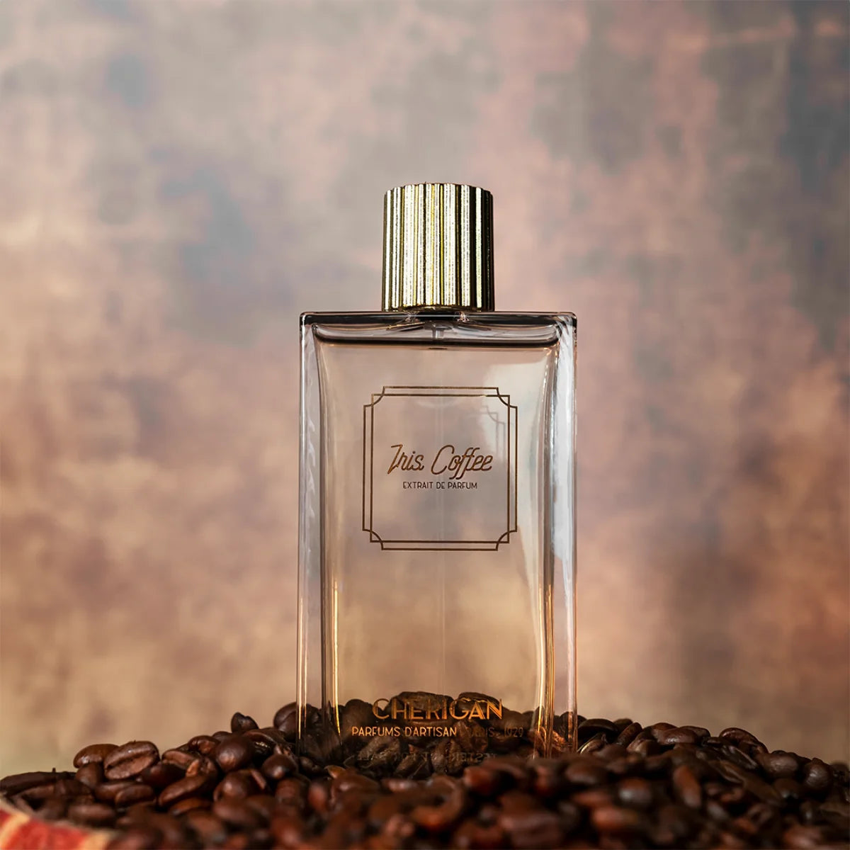 Cherigan - Iris Coffee Parfumflakon mit goldfarbenem Verschluss und Kaffeebohnen vor warmem Hintergrund