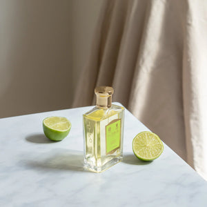 Floris - Jermyn Street Parfümflakon mit zitronengrüner Etikette und goldfarbenem Verschluss auf Marmoroberfläche mit Limettenhälften