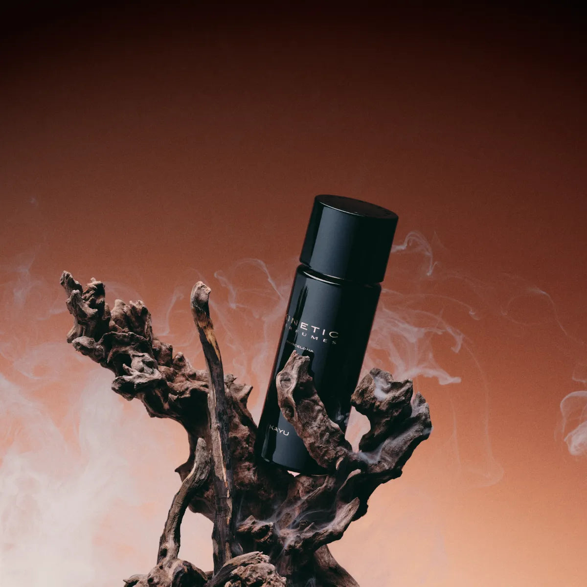 Kinetic Perfumes - Kayu schwarzer Flakon mit mattem Finish auf organischem Holzstück vor warmem Hintergrund mit Rauch