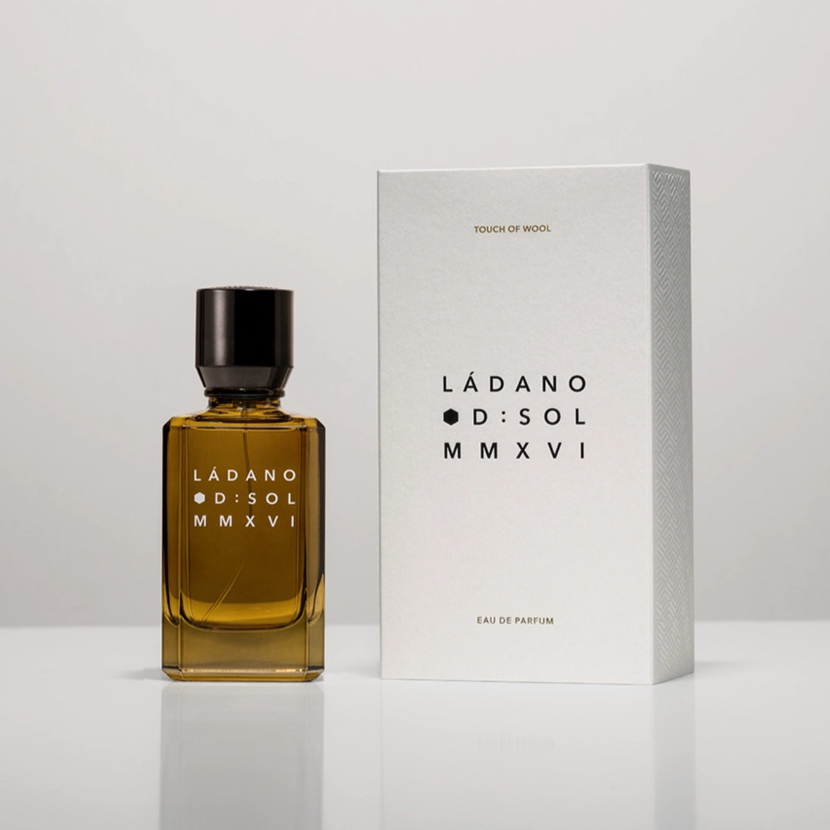 D:SOL MMXVI - Ládano Parfumflakon in bernsteinfarbenem Glas mit schwarzem Verschluss und weißer Verpackung