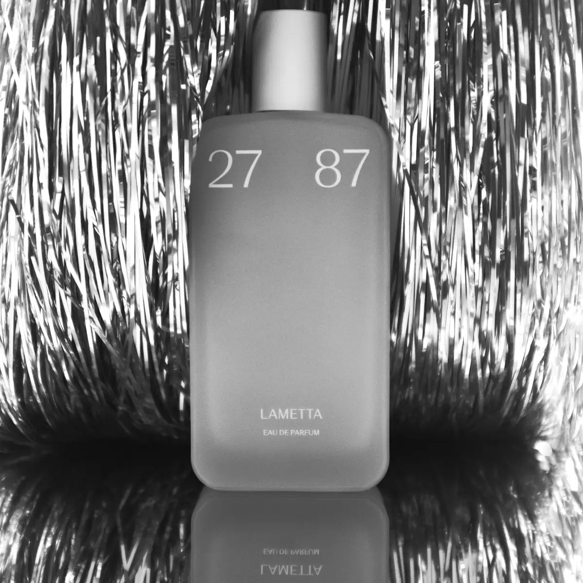 27 87 Perfumes - Lametta mit mattem Flakon vor reflektierendem silbernem Lametta-Hintergrund