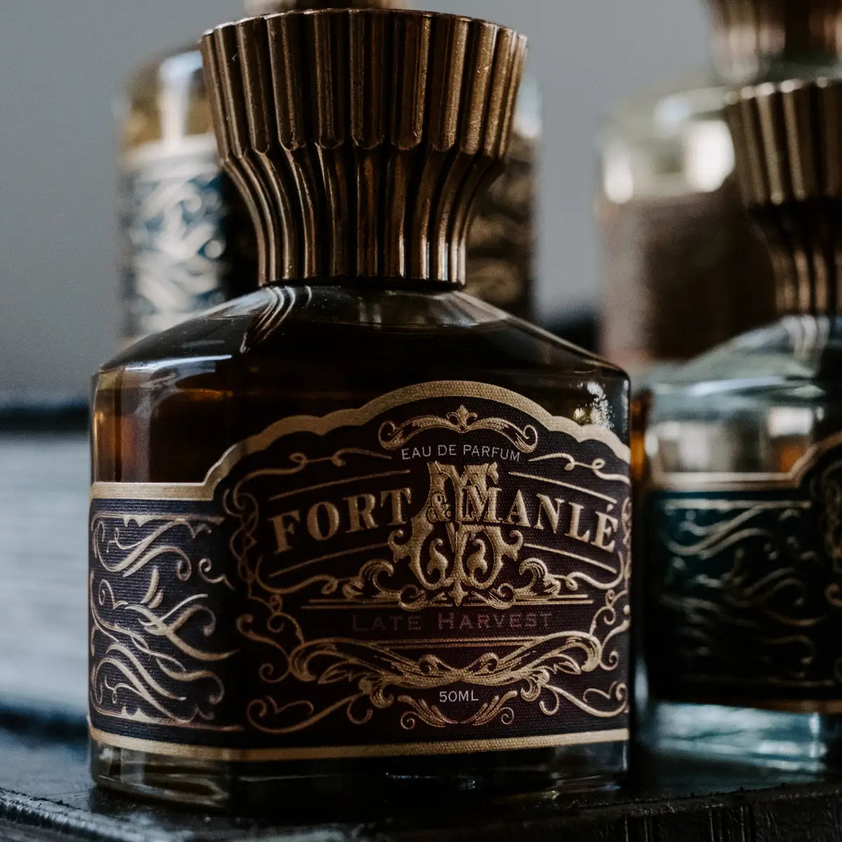 Fort & Manlé - Late Harvest Parfümflakon mit kunstvollem, dunklem Etikett und verziertem goldfarbenem Verschluss in Nahaufnahme
