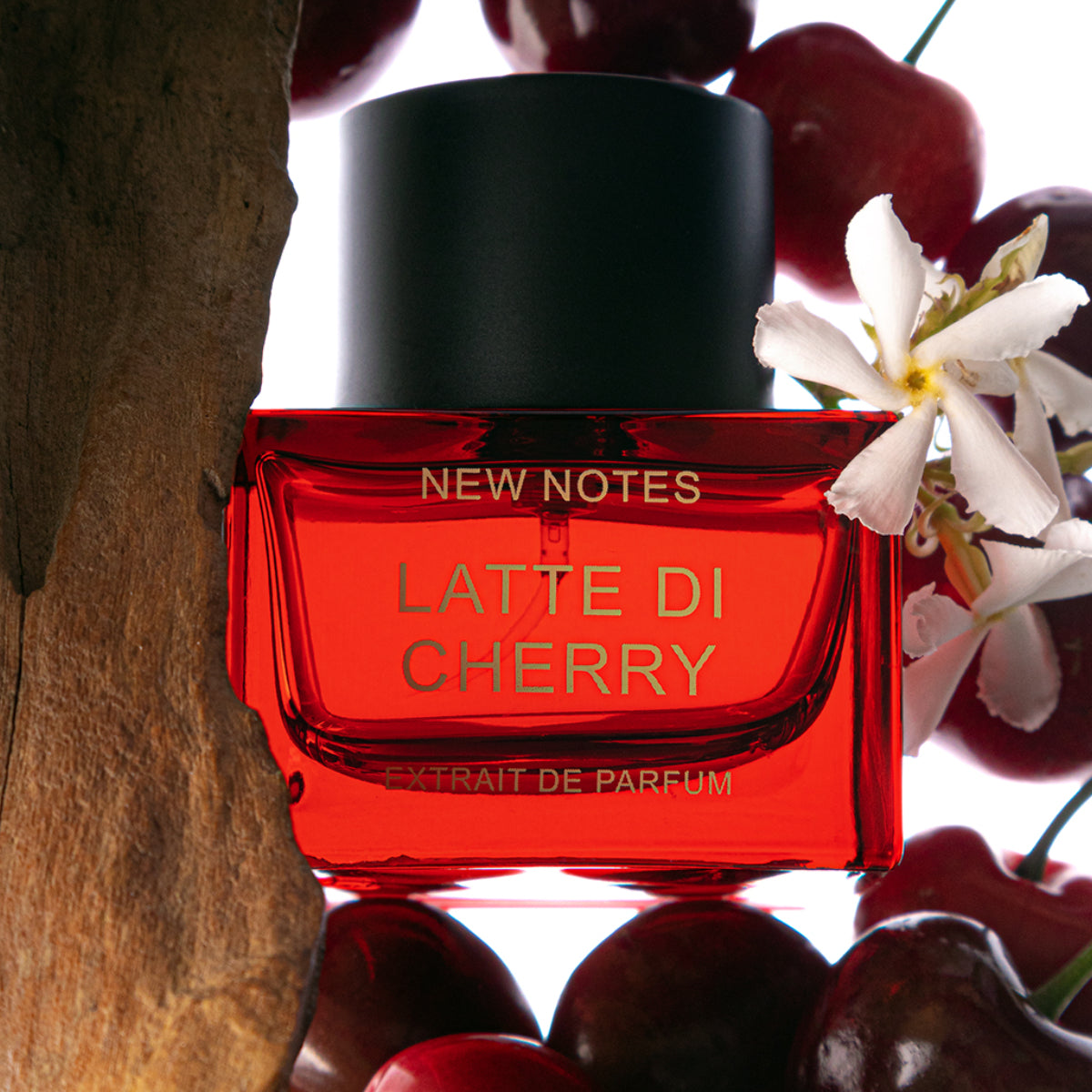 New Notes - Contemporary Blend Collection - Latte di Cherry präsentiert roten Flakon vor Kirschen und Blüten ansprechend inszeniert