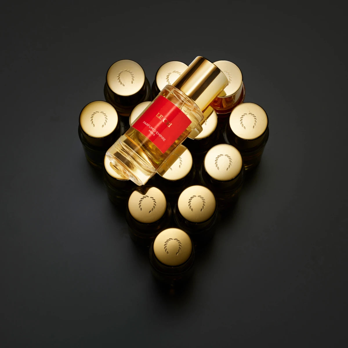 Parfum d'Empire - LE CRI de la lumière Parfumflakon mit goldenem Verschluss und rotem Etikett auf dunklem Hintergrund
