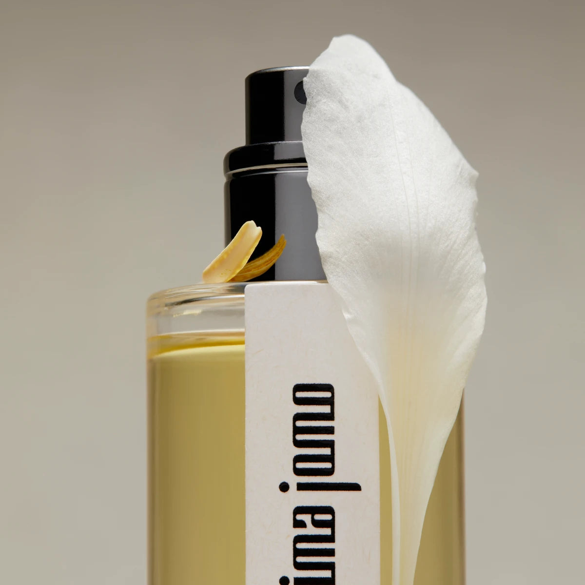 Hima Jomo - Treasures - Loon Flakon mit schwarzem Sprühkopf und weißer Blüte vor neutralem Hintergrund