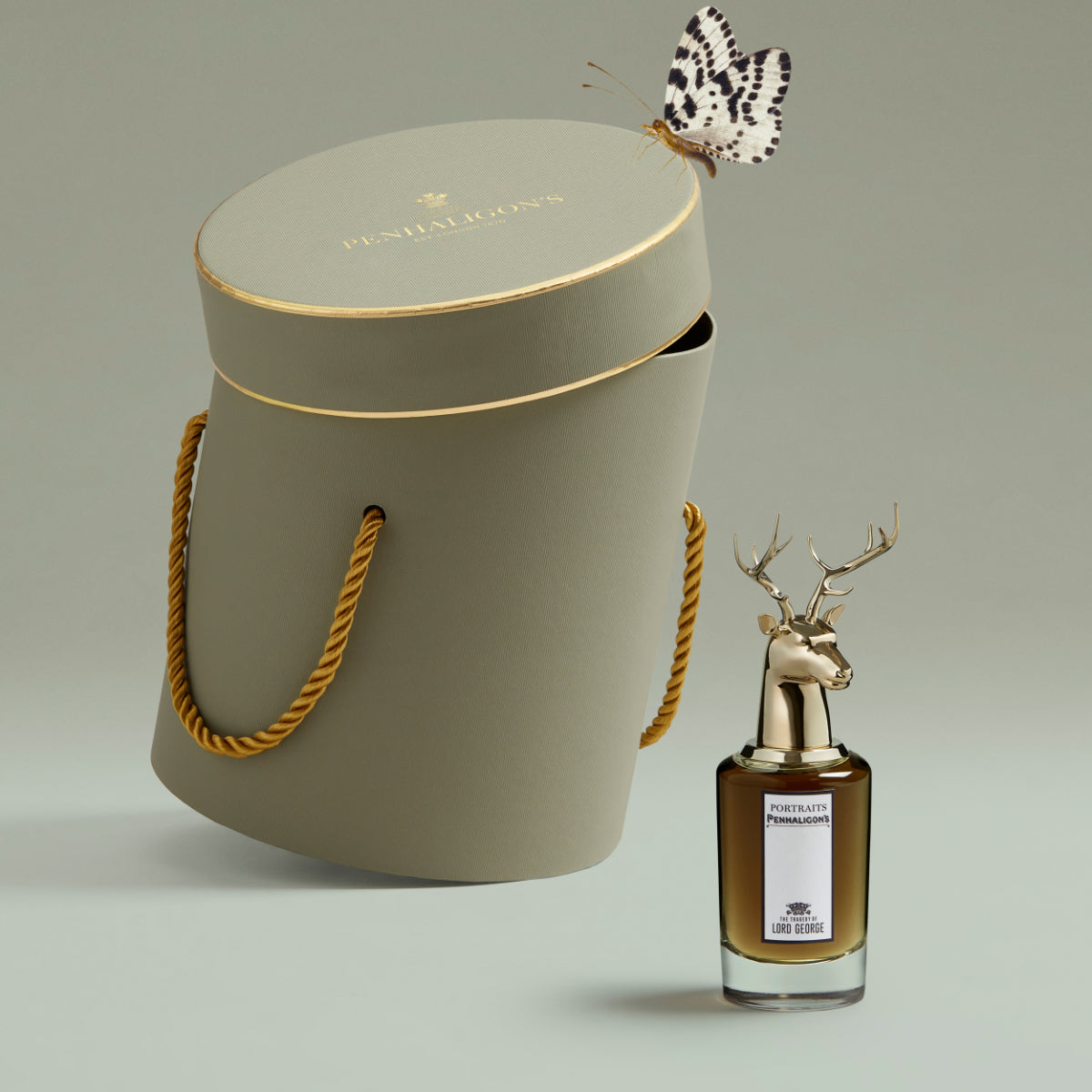 Penhaligon's - Portraits - The Tragedy of Lord George Flakon mit Hirschkopf neben elegantem Verpackungshut und Schmetterling