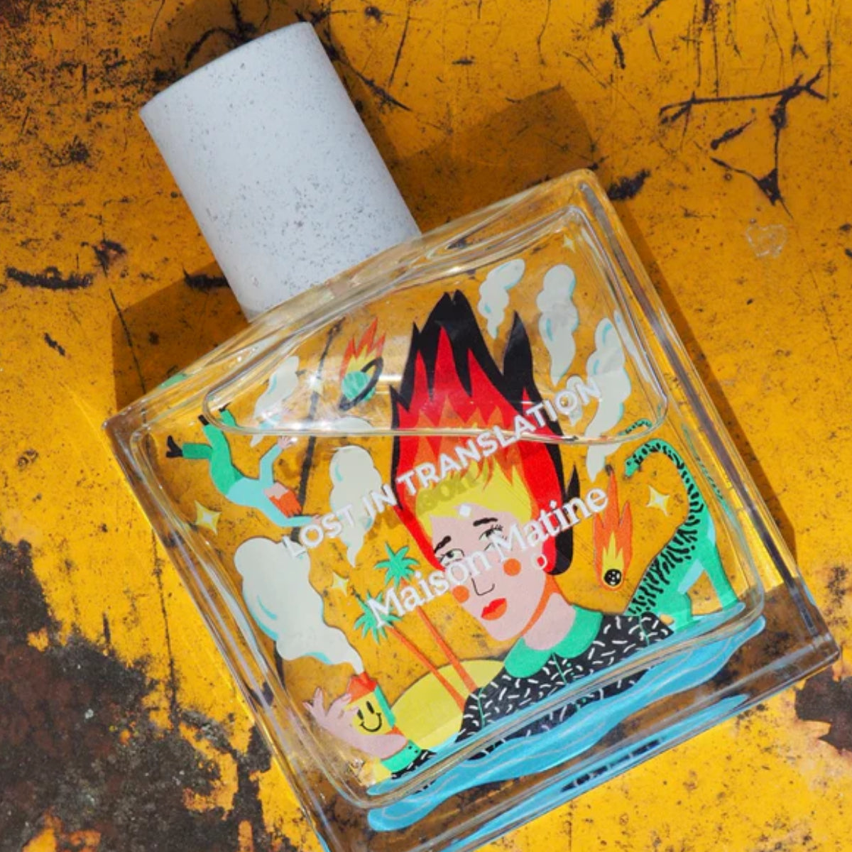 Maison Matine - Lost in Translation Parfumflakon mit surrealer Illustration einer Frau und feurigen Elementen auf klarem Glas