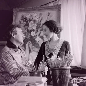 Cherigan - Lovers in Pink zeigt ein Künstlerpaar im Atelier vor einem blumigen Gemälde in nostalgischer Schwarz-Weiß-Atmosphäre