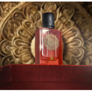 Eau De Moe - Lulu Parfüm in rotem Glas mit goldenem Mandala, schwarzem Verschluss, vor kunstvollem Hintergrund präsentiert
