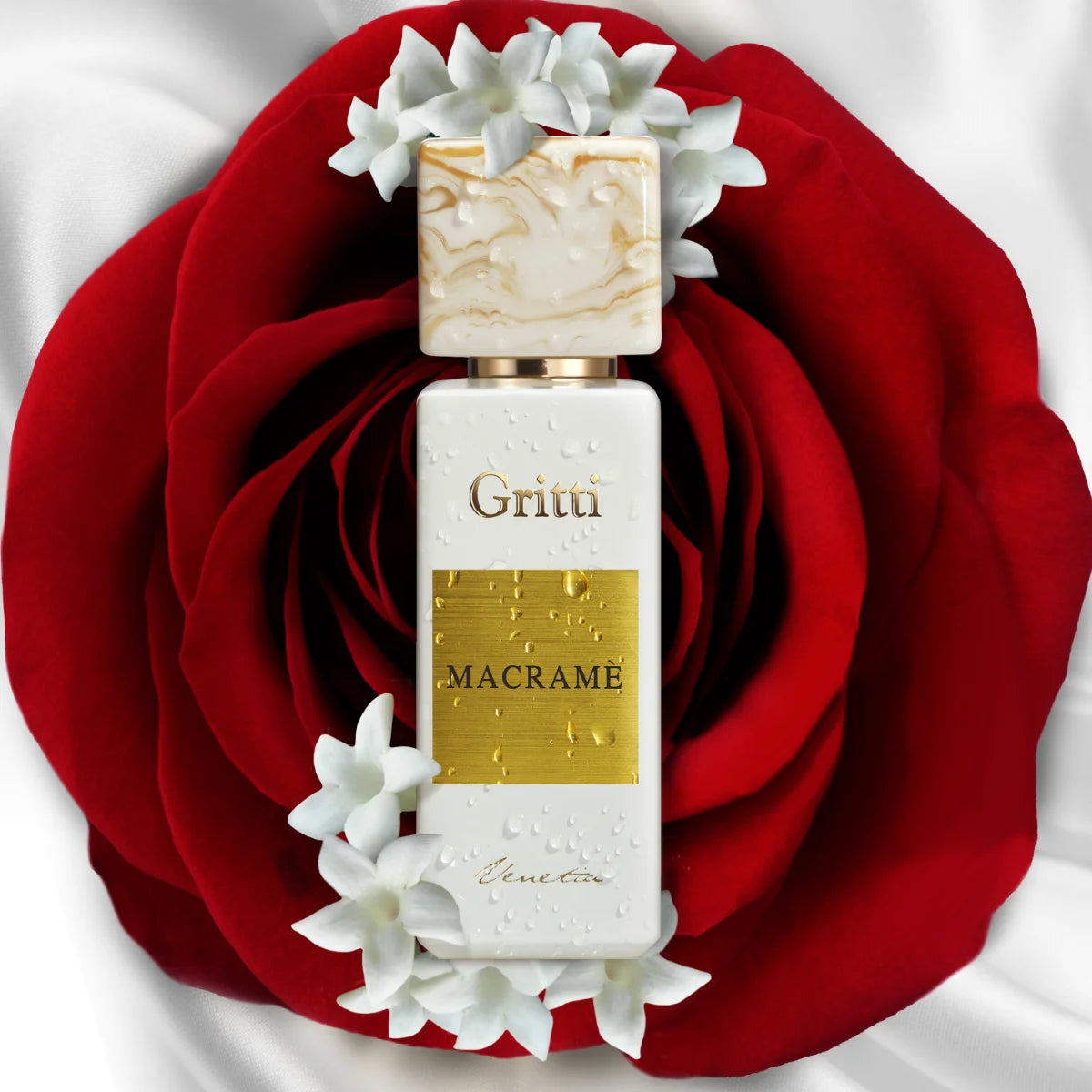 Gritti - White Collection - Macramé edler weißer Flakon mit goldfarbenem Etikett auf roter Rosenblüte und weißen Blumenarrangements