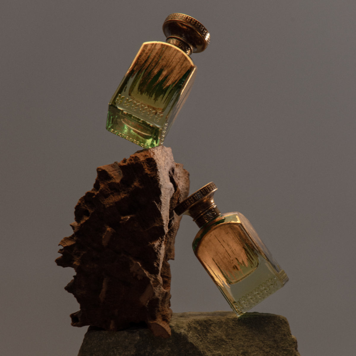 Anfas - Fosol Collection - Mada Parfumflakons mit goldfarbenem Verschluss auf rustikalen Natursteinen inszeniert
