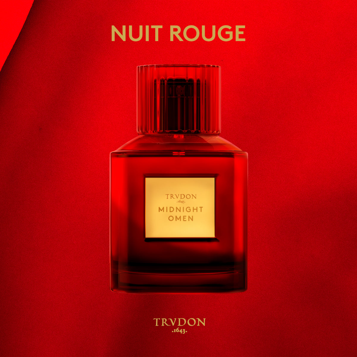 Trudon - Nuit Rouge - Midnight Omen Parfumflakon in tiefrotem Glas mit goldfarbenem Etikett vor rotem Hintergrund