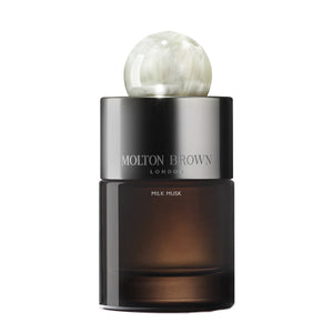Molton Brown - Milk Musk Parfumflakon mit dunklem Glas und perlmuttschimmerndem, rundem Verschluss vor weißem Hintergrund
