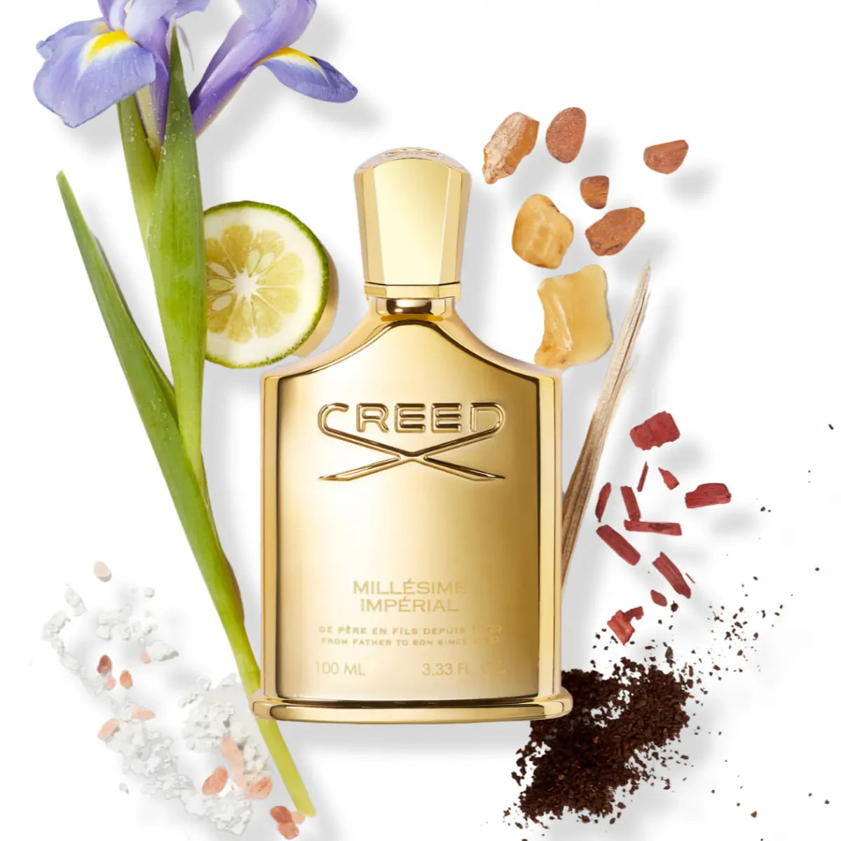 Creed - Millésime Imperial Parfumflakon in goldener Optik umgeben von natürlichen Duftnoten auf weißem Hintergrund
