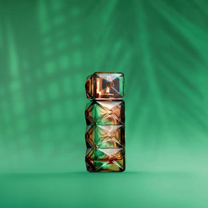 FO'AH - Collection Mémoires d'une Palmeraie - 02 Parfumflakon mit facettiertem braun-grünem Design vor grünem Hintergrund