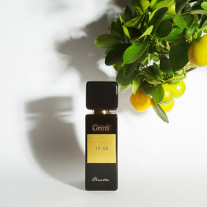 Gritti - Black Collection - 19-68 Parfumflakon in schwarzem Design mit goldenem Etikett und Zitrusfrüchten im Hintergrund
