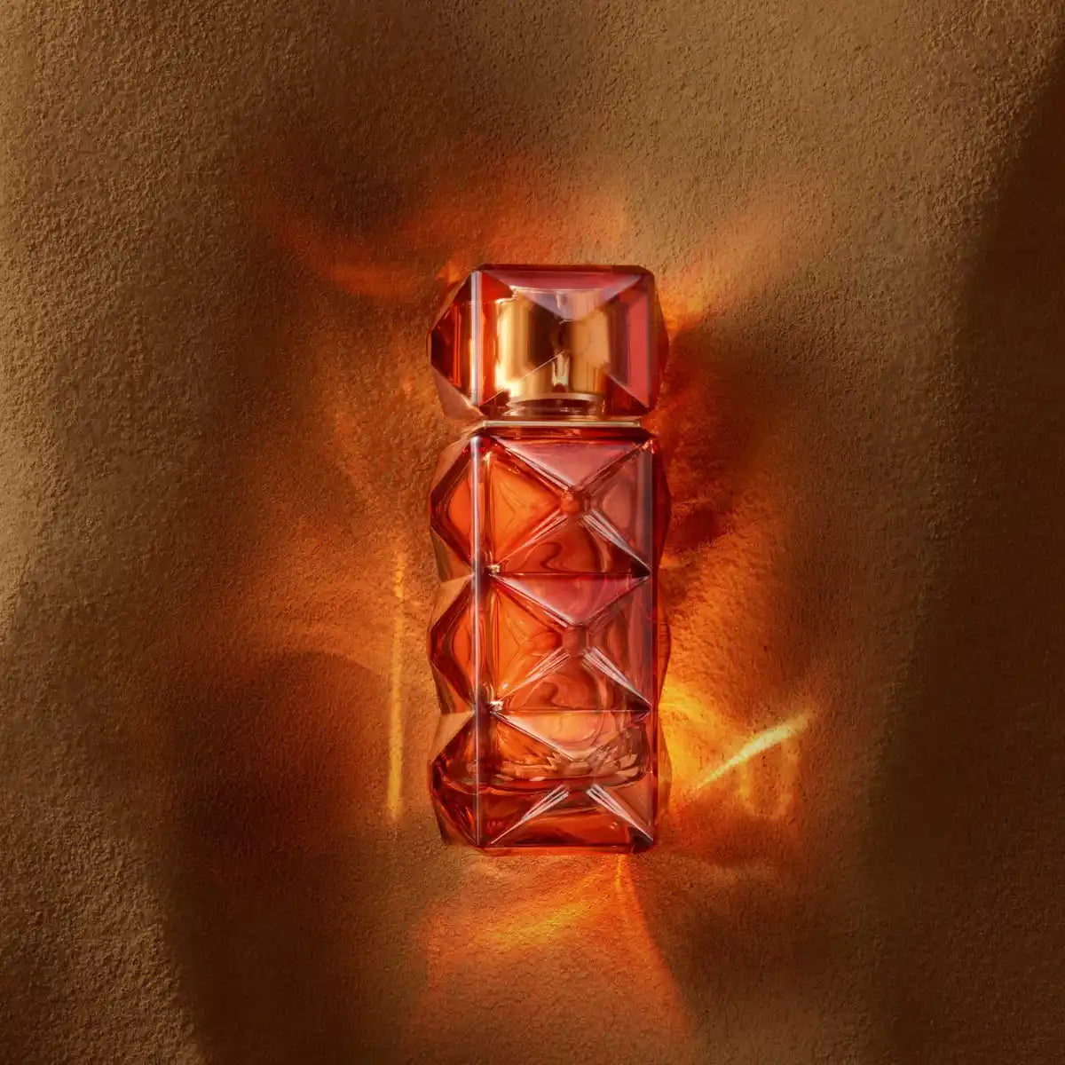 FO'AH - Collection Mémoires d'une Palmeraie - 14 Parfumflakon mit facettenreichem bernsteinfarbenem Design auf warmem Hintergrund