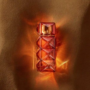 FO'AH - Collection Mémoires d'une Palmeraie - 14 Parfumflakon mit facettenreichem bernsteinfarbenem Design auf warmem Hintergrund