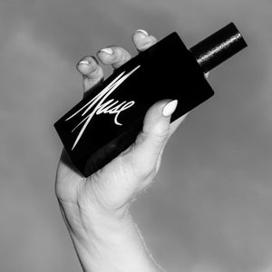 Andrea Maack Parfums - Muse schwarzer Flakon mit weißer kalligrafischer Schrift elegant in Hand gehalten