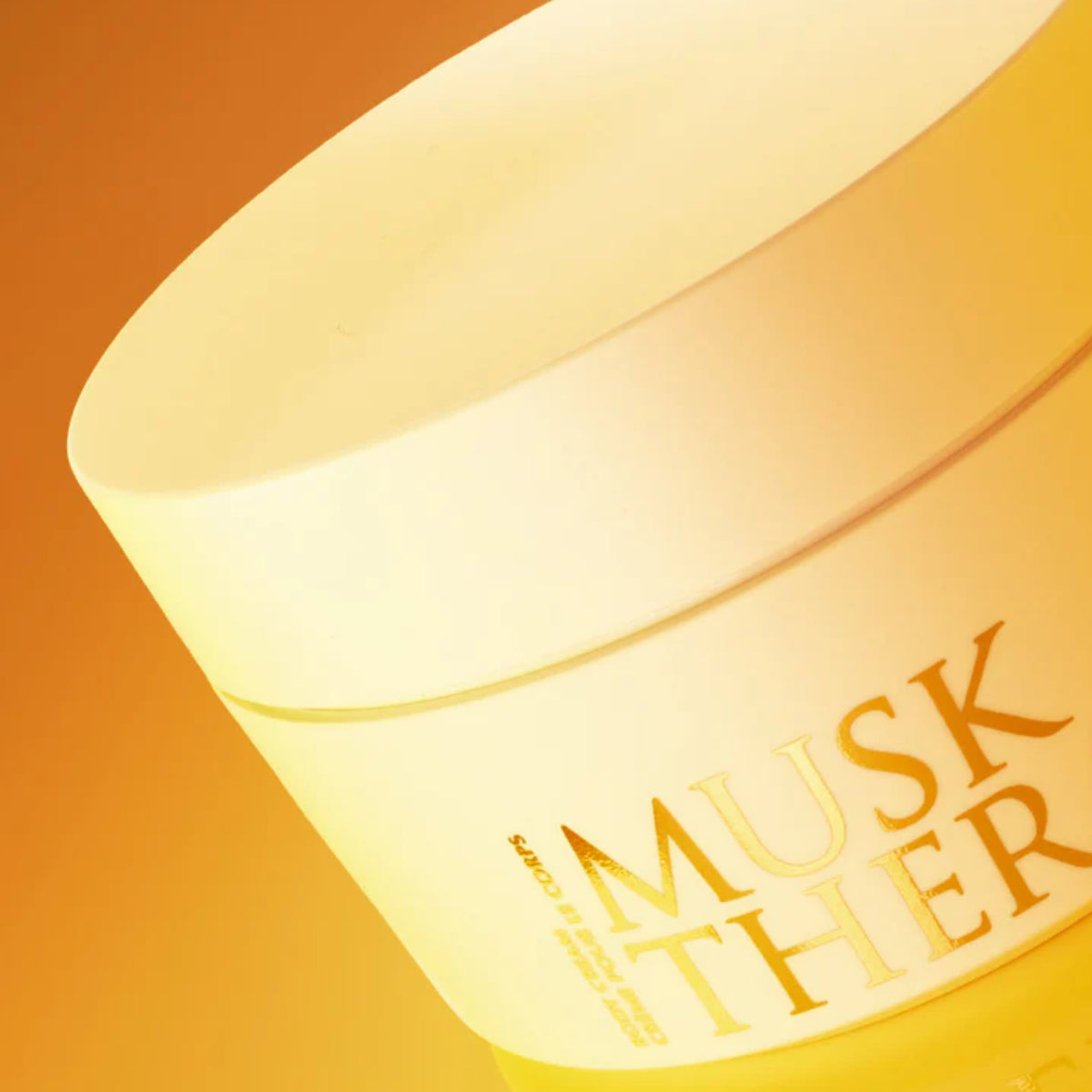 Initio - Musk Therapy - Body Cream goldgelbe Cremedose mit dezentem Schriftzug vor warmem Hintergrund