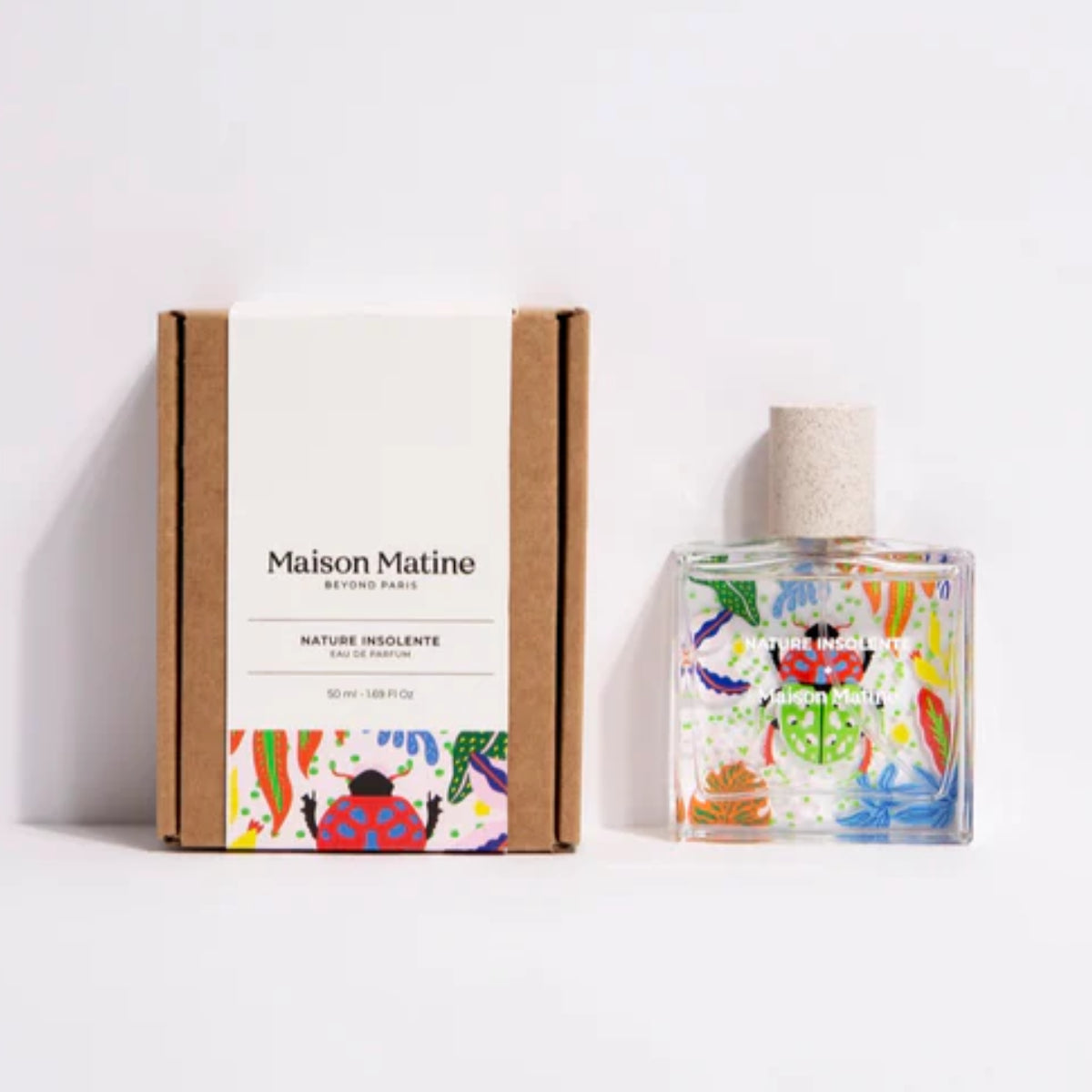 Maison Matine - Nature Insolente Parfumflakon mit farbenfrohen Naturmotiven und Käferillustration neben schlichter Kartonverpackung