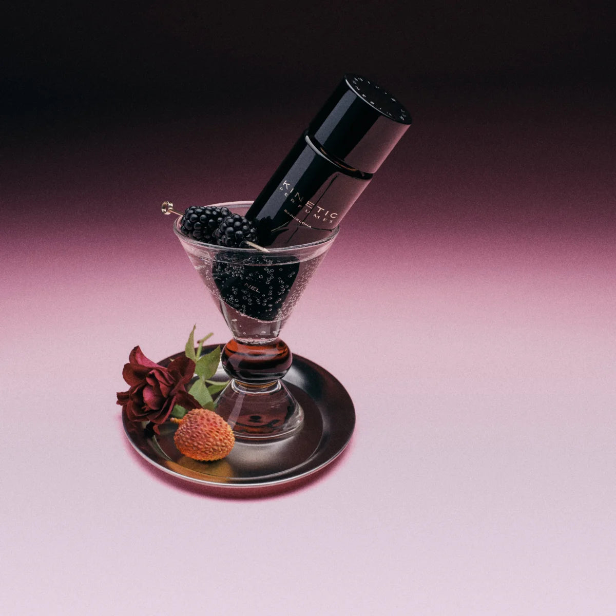 Kinetic Perfumes - Nel Parfumflakon im schwarzen Design in einem Glas mit Brombeeren und frischen Blüten arrangiert