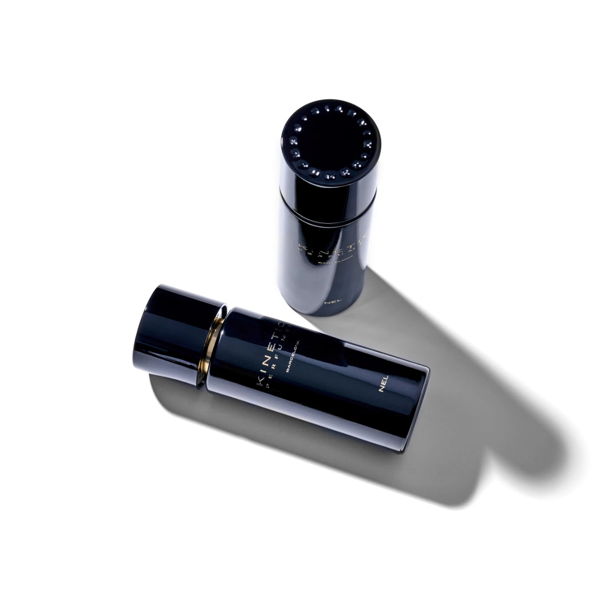 Kinetic Perfumes - Nel zwei glänzende schwarze Parfumflakons mit goldener Schrift auf weißem Hintergrund mit Schattenwurf