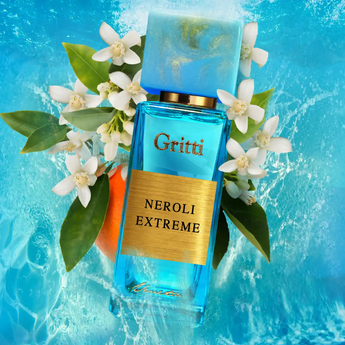 Gritti - Smaragd Collection - Neroli Extreme Parfumflakon in leuchtendem Blau umgeben von Orangenblüten vor Wasserhintergrund