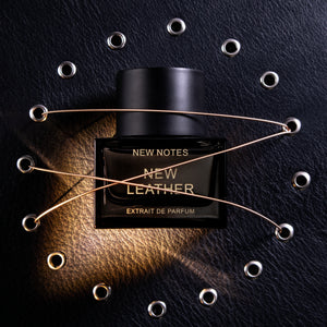 New Notes - Contemporary Blend Collection - New Leather Parfumflakon in schwarzem Design mit goldener Schrift und Akzenten auf schwarzem Lederhintergrund