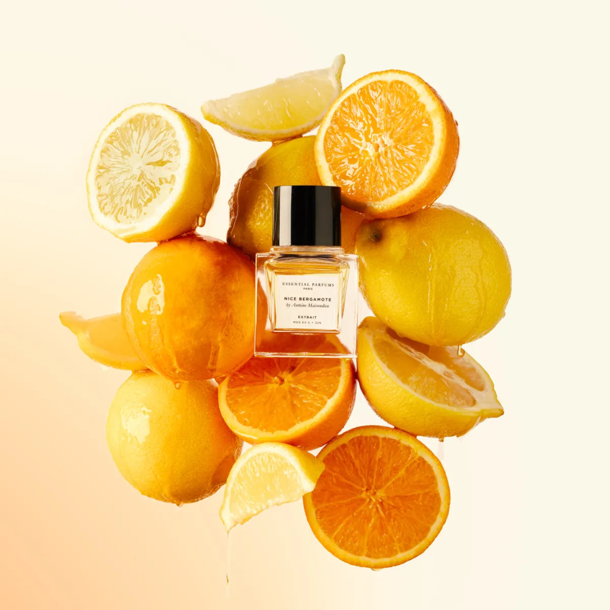 Essential Parfums - Nice Bergamote - Extrait de Parfum zeigt klaren Flakon umgeben von frischen Zitronen und Orangenhälften
