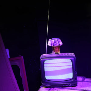 Filippo Sorcinelli - Unum - Oceano Viola zeigt Flakon mit violettem Deckel auf altem Fernseher vor dunklem Hintergrund