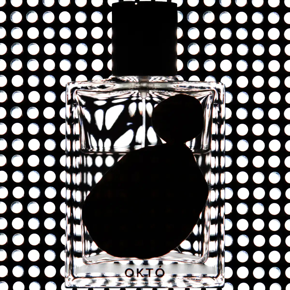 OHTOP - Októ Parfumflasche vor geometrischem Lichtmuster mit klarer Form und minimalistischem Design