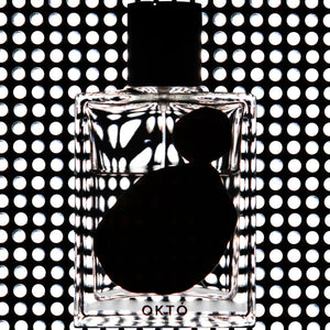 OHTOP - Októ Parfumflasche vor geometrischem Lichtmuster mit klarer Form und minimalistischem Design