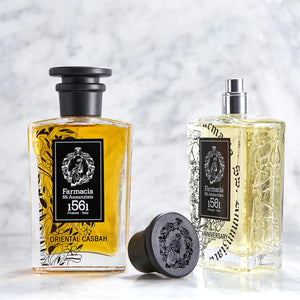 Farmacia SS. Annunziata - Oriental Casbah Parfumflakon mit bernsteinfarbener Flüssigkeit und schwarzem Verschluss vor hellem Marmorhintergrund
