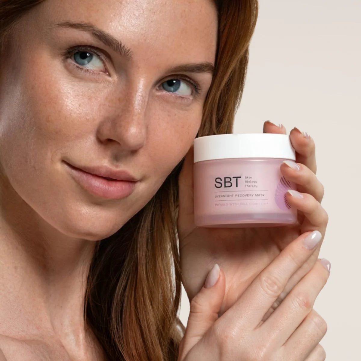 SBT - Sensitive - Overnight Recovery Mask in rosa Tiegel gehalten von Frau für regenerierende und glättende Nachtpflege