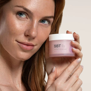 SBT - Sensitive - Overnight Recovery Mask in rosa Tiegel gehalten von Frau für regenerierende und glättende Nachtpflege