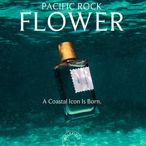 Goldfield & Banks - Pacific Rock Flower Parfumflakon mit goldenem Verschluss in klarem Wasser vor aquatischem Hintergrund