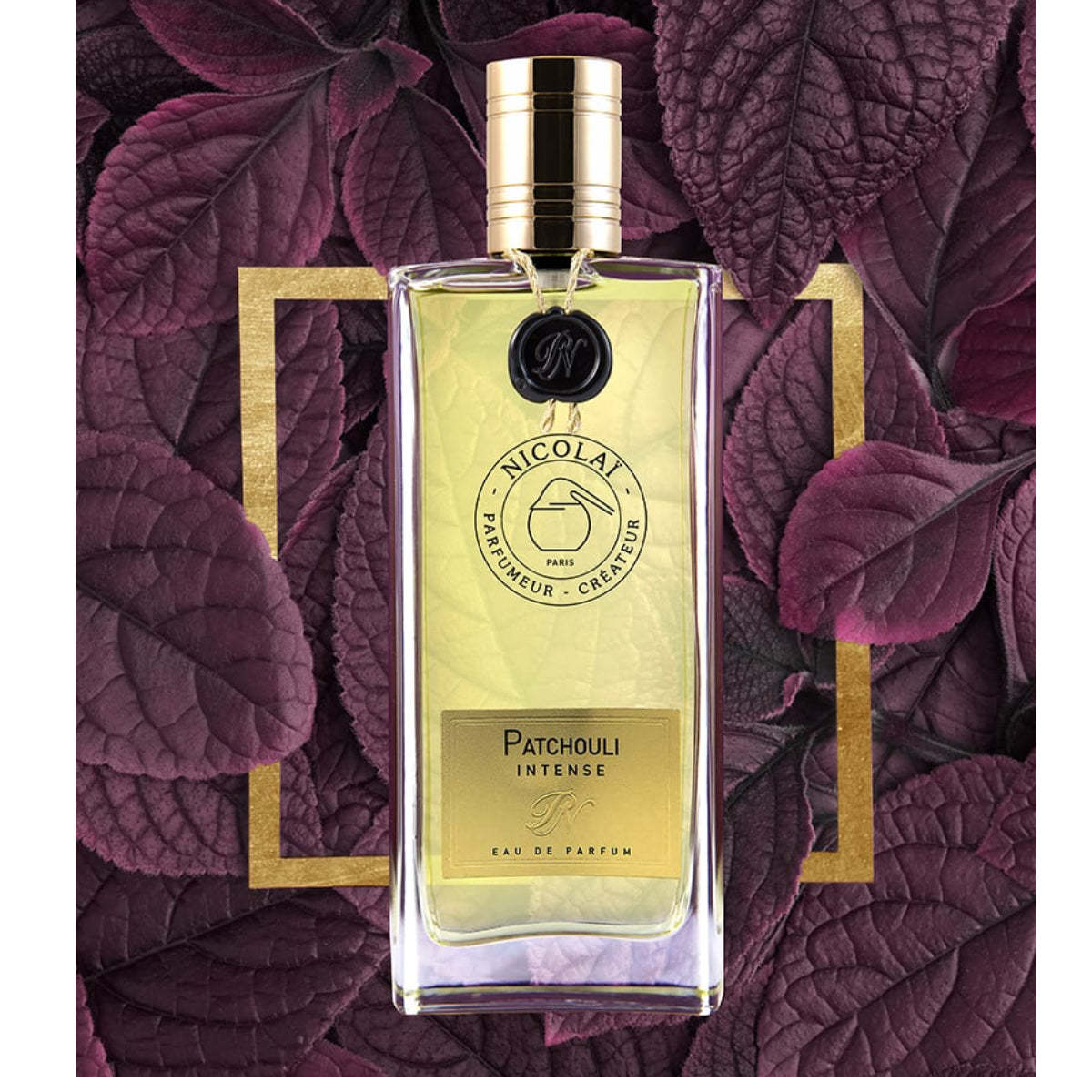 Nicolaï - Patchouli Intense elegant klarer Flakon mit goldfarbenem Verschluss vor dunkelviolettem Blattmotiv