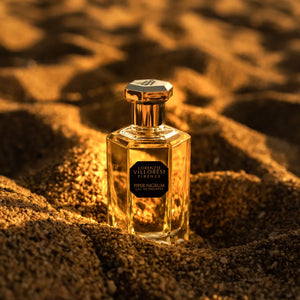 Lorenzo Villoresi Piper Nigrum Eau de Toilette in clear faceted bottle with gold hexagonal cap on textured sandy background